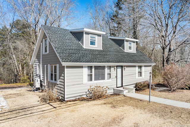 view of front facade featuring driveway and roof with shingles