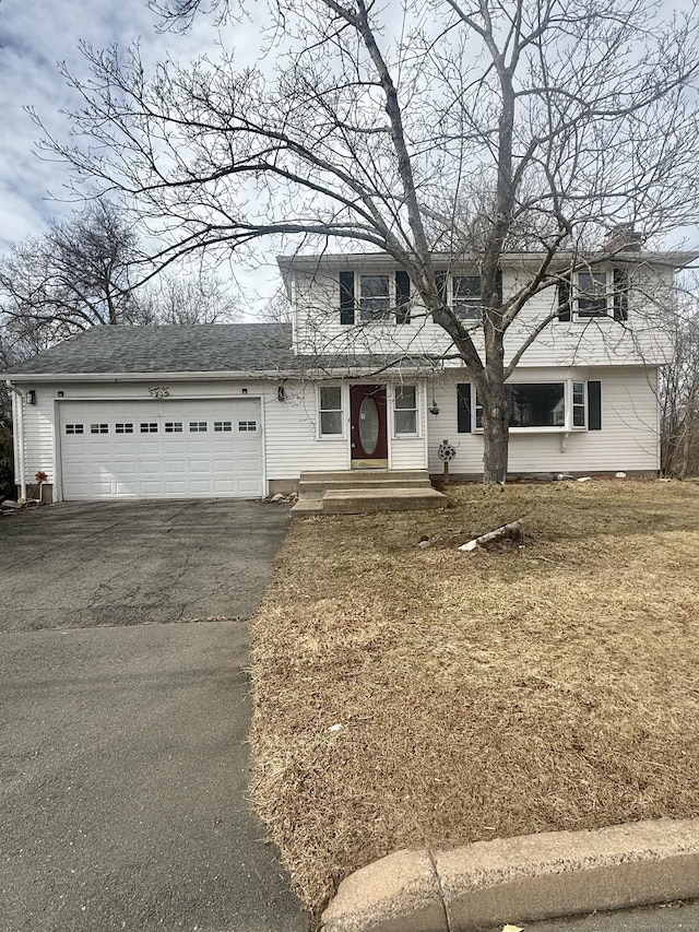 traditional-style home featuring a garage and driveway