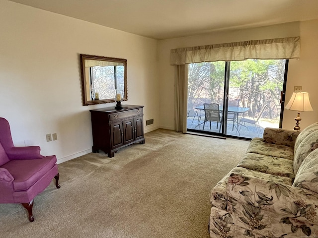 living area featuring visible vents, light carpet, and baseboards