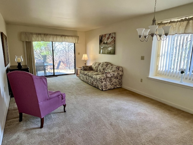 living room featuring baseboards, an inviting chandelier, and carpet floors