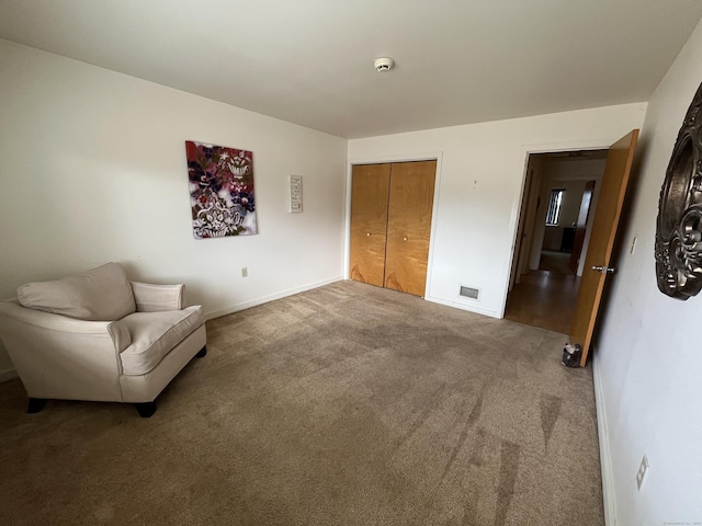 living area with baseboards, visible vents, and carpet floors