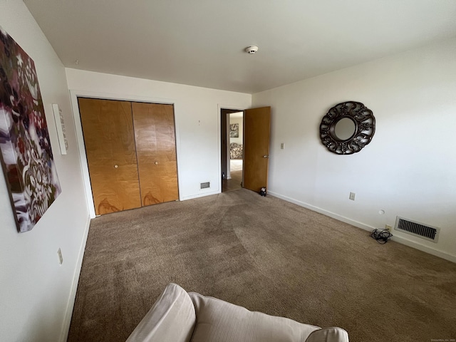 bedroom with visible vents, carpet floors, baseboards, and a closet