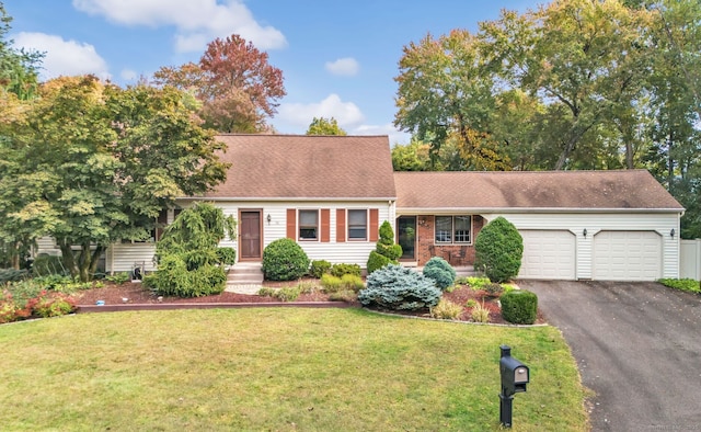 new england style home featuring a front yard, a garage, and driveway