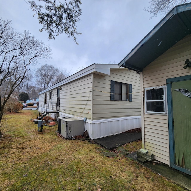 view of home's exterior featuring ac unit and a lawn