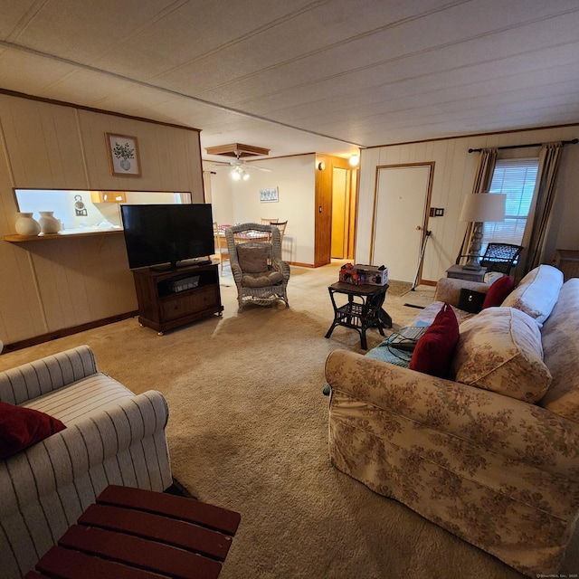 carpeted living area with a ceiling fan and baseboards