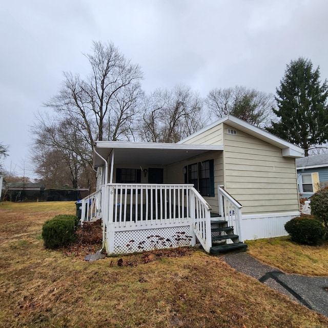 manufactured / mobile home featuring a porch and a front lawn