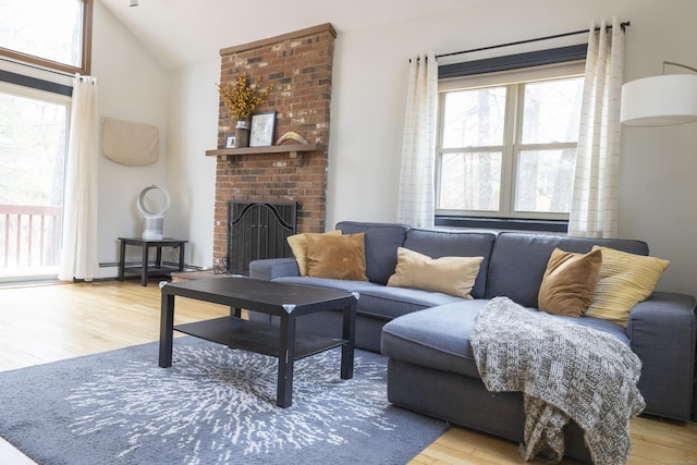 living room with lofted ceiling, wood finished floors, and a fireplace