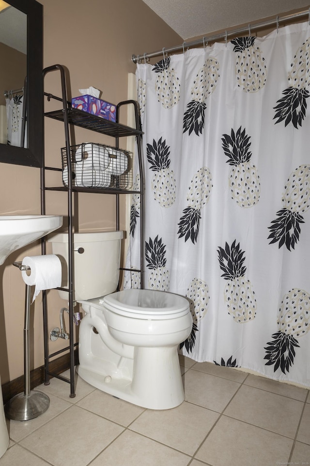 full bathroom with a shower with curtain, toilet, and tile patterned flooring