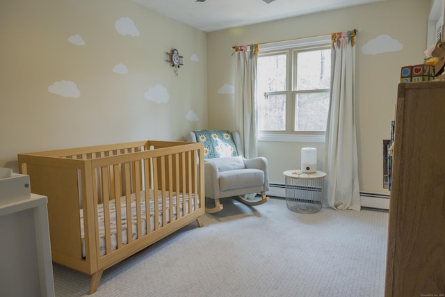 carpeted bedroom with a crib and baseboard heating