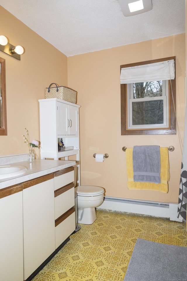 bathroom with a baseboard radiator, toilet, and vanity