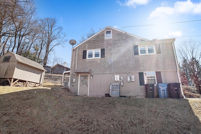 rear view of property featuring an outbuilding, central air condition unit, and a shed