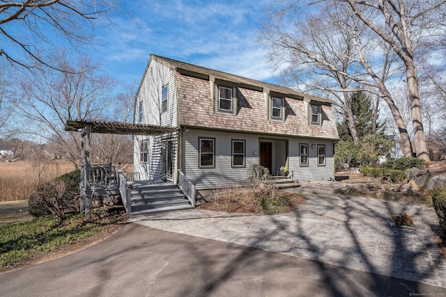 dutch colonial featuring a gambrel roof and a pergola