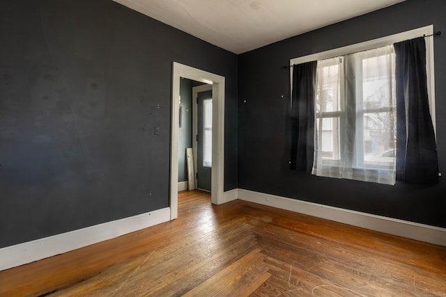 empty room with baseboards and wood finished floors