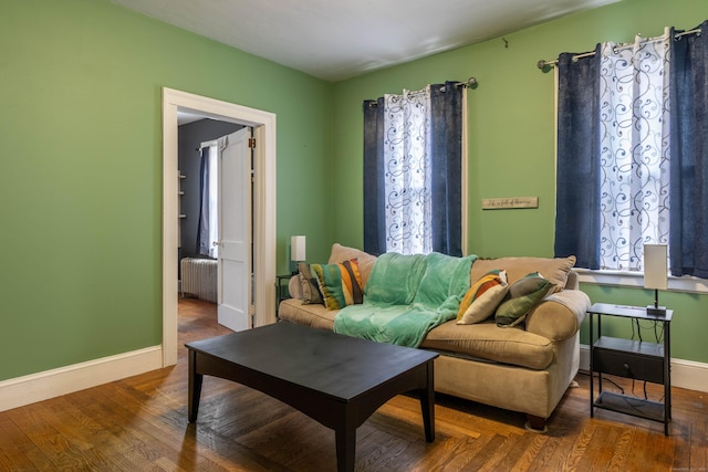 living area with radiator, wood finished floors, and baseboards