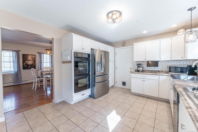 kitchen with light tile patterned floors, decorative backsplash, appliances with stainless steel finishes, and white cabinetry