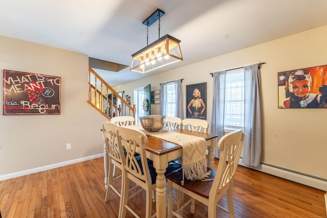 dining room with stairway, baseboards, and hardwood / wood-style floors