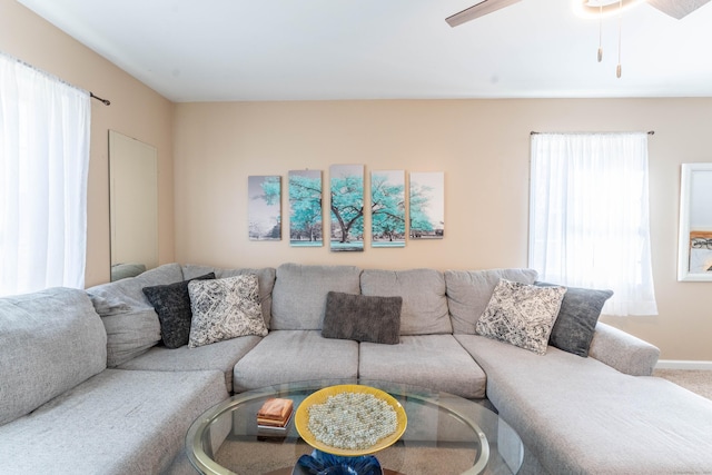 carpeted living area featuring baseboards and ceiling fan