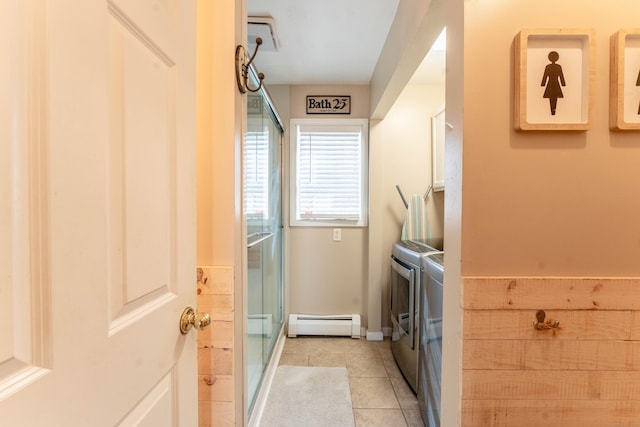 clothes washing area featuring laundry area, light tile patterned floors, independent washer and dryer, and baseboard heating