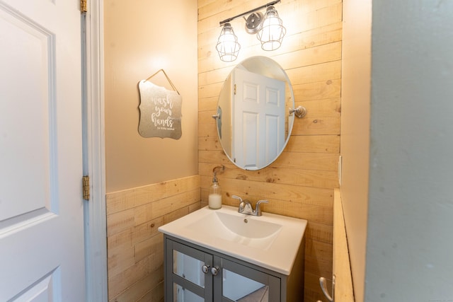 bathroom featuring vanity and wood walls