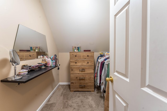 walk in closet with vaulted ceiling and carpet flooring