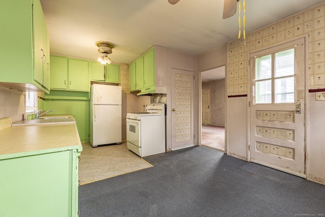 kitchen with a sink, under cabinet range hood, white appliances, green cabinets, and light countertops