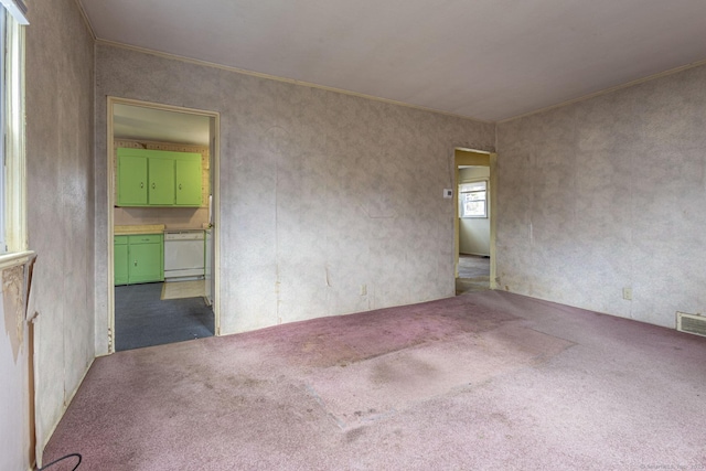 unfurnished room featuring carpet flooring, crown molding, and visible vents