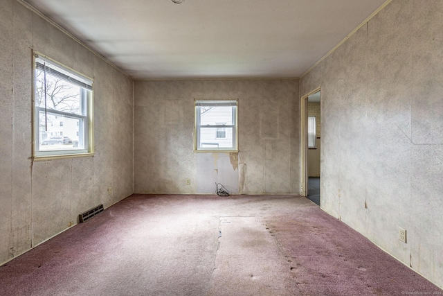 unfurnished room with carpet, a healthy amount of sunlight, and visible vents