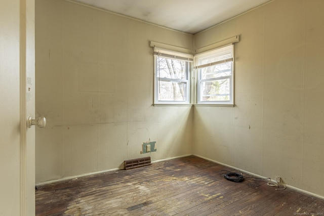 unfurnished room featuring hardwood / wood-style flooring and visible vents