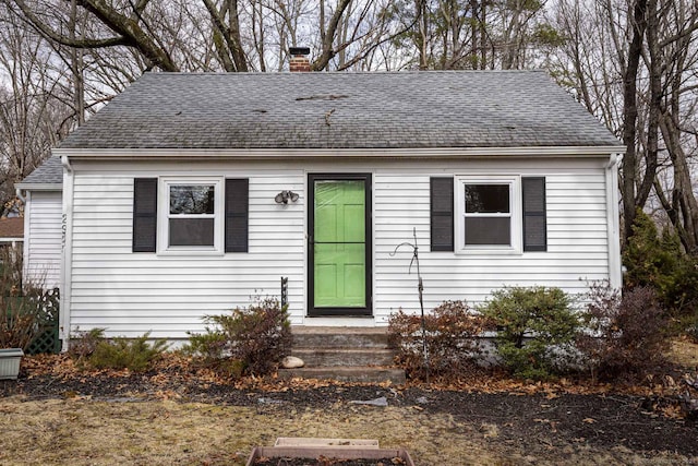 view of front of home featuring a chimney and a shingled roof