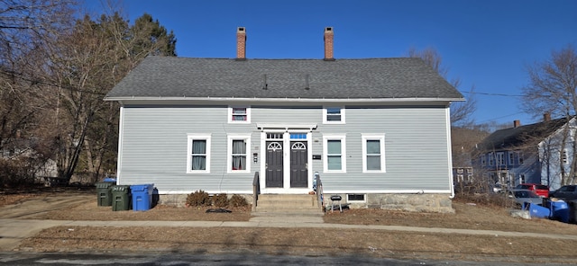 exterior space featuring a chimney and roof with shingles