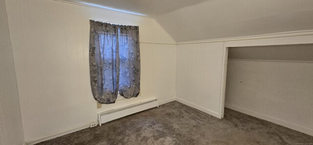 unfurnished bedroom with a baseboard heating unit, vaulted ceiling, carpet, and baseboards