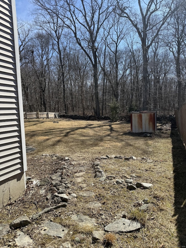 view of yard featuring an outbuilding and fence