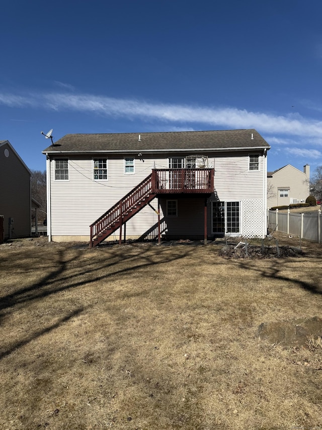 rear view of house with stairway, a lawn, a deck, and fence