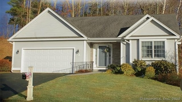 view of front of house with a garage, driveway, and a front lawn