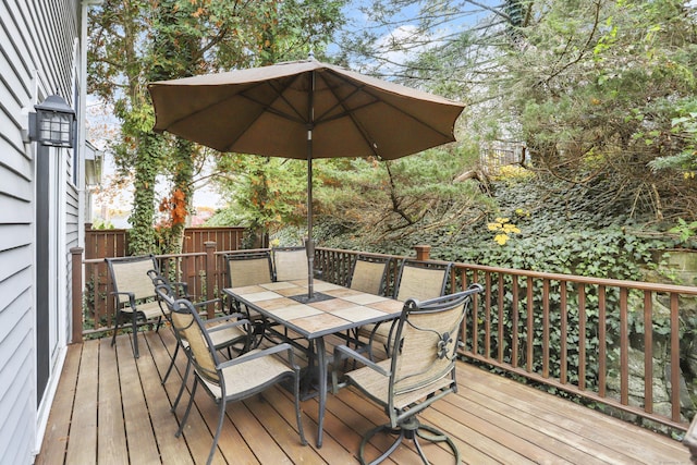 wooden terrace featuring outdoor dining space and fence