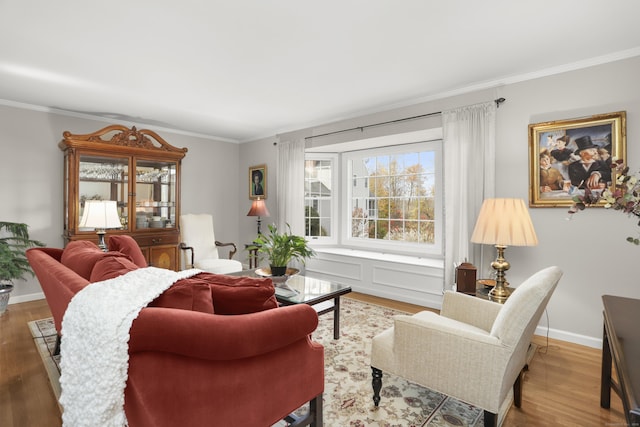 living area with crown molding, baseboards, and wood finished floors