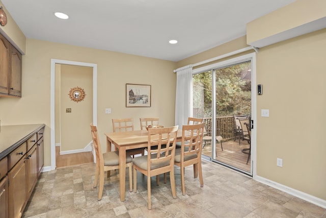 dining area featuring recessed lighting, stone finish flooring, and baseboards