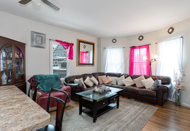 living area featuring a wealth of natural light, a ceiling fan, and wood finished floors