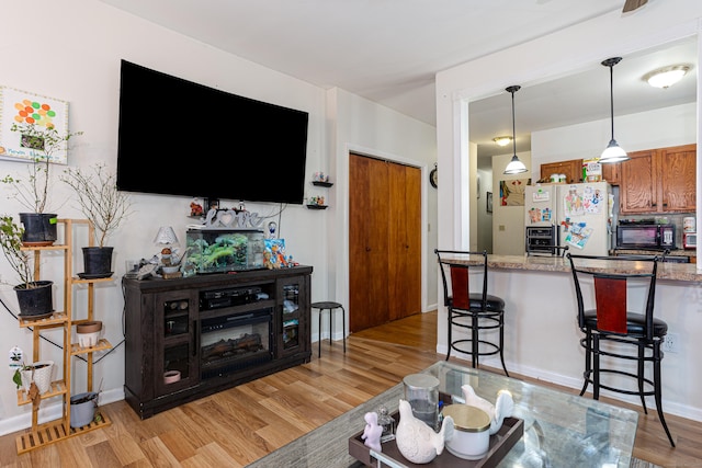 living room featuring light wood-type flooring and baseboards