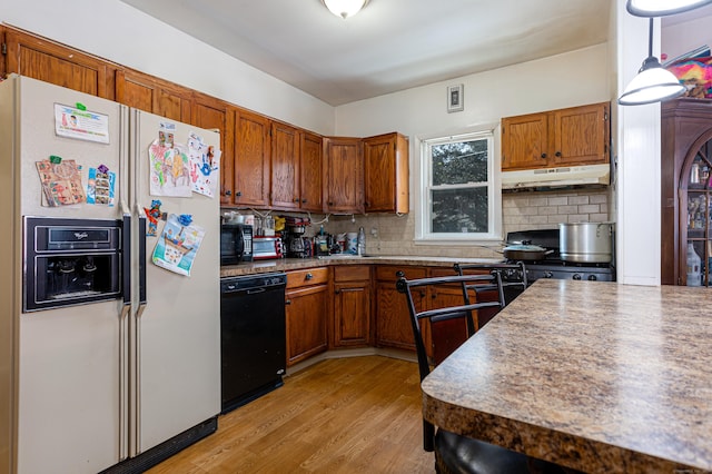 kitchen with visible vents, light wood-type flooring, black appliances, under cabinet range hood, and tasteful backsplash