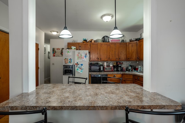 kitchen featuring brown cabinets, backsplash, white refrigerator with ice dispenser, a peninsula, and hanging light fixtures