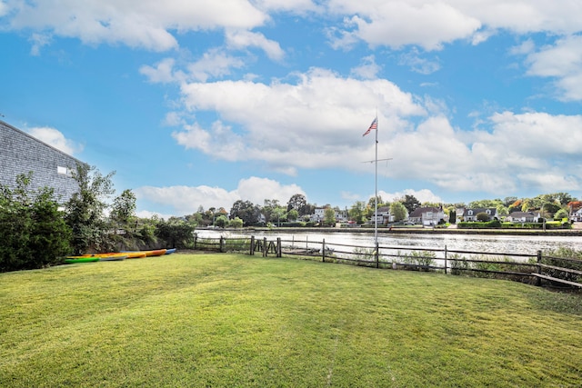 view of yard featuring fence and a water view