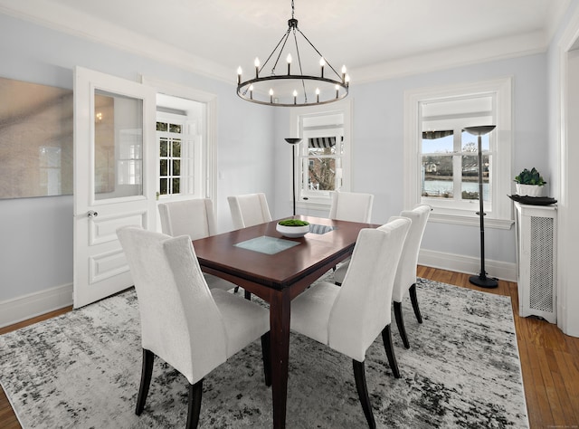 dining room featuring ornamental molding, baseboards, and wood finished floors