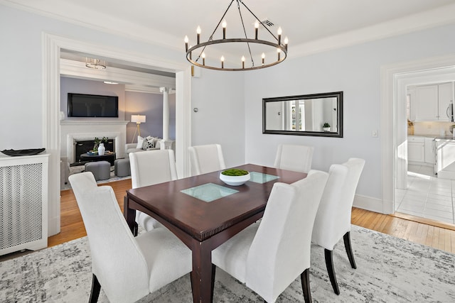 dining room with visible vents, a fireplace, baseboards, and light wood-style floors