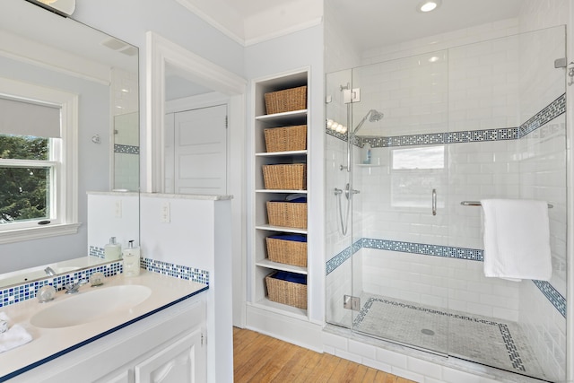 full bath with a stall shower, vanity, and wood finished floors