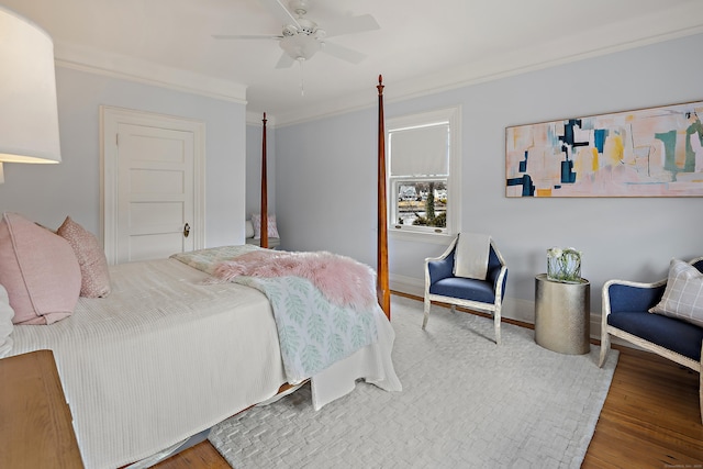 bedroom with baseboards, wood finished floors, ornamental molding, and a ceiling fan