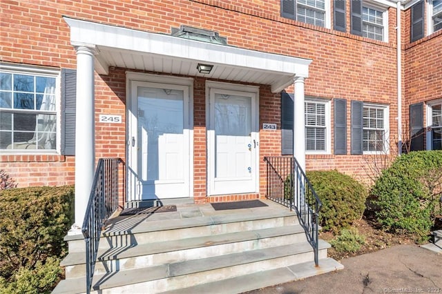 view of exterior entry with brick siding