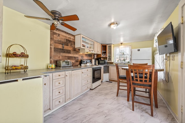 kitchen featuring marble finish floor, freestanding refrigerator, and range with electric cooktop