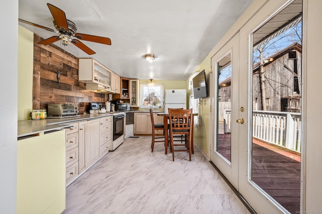 kitchen featuring black microwave, stainless steel counters, freestanding refrigerator, electric stove, and marble finish floor