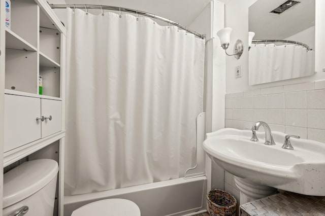 full bath featuring tasteful backsplash, tile walls, toilet, and shower / bath combo